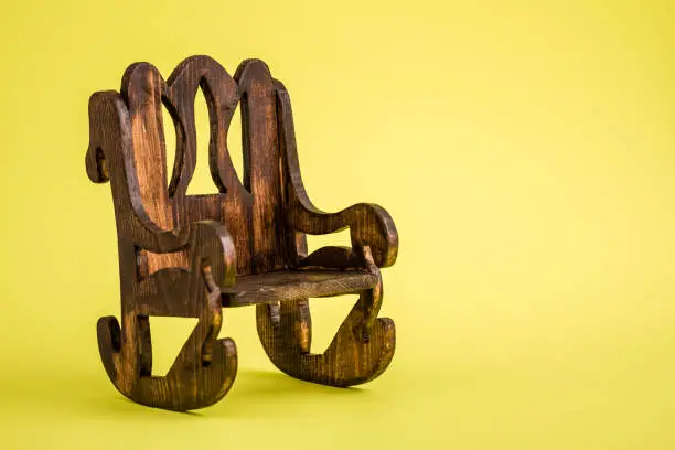 Handmade miniature wooden chairs on yellow background