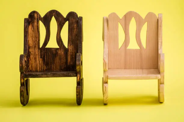 Handmade miniature wooden chairs on yellow background
