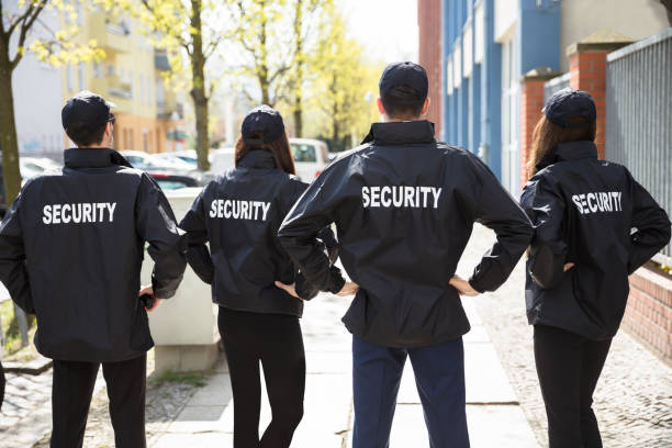 istock Rear View Of Security Guards Standing In A Row 975118150