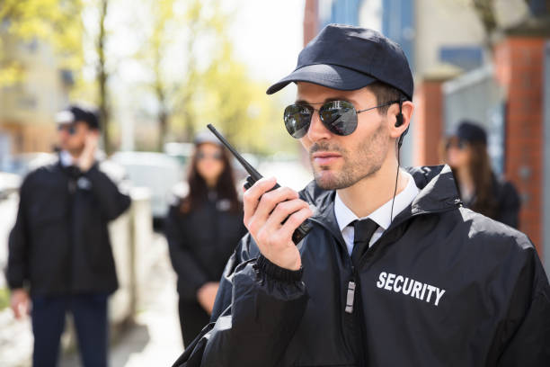 Portrait Of A Male Security Guard Portrait Of A Male Security Guard Talking On Walkie Talkie security staff stock pictures, royalty-free photos & images