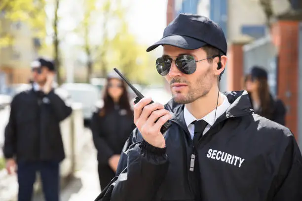 Portrait Of A Male Security Guard Talking On Walkie Talkie