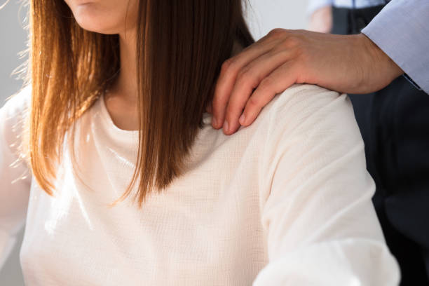 Businessman Sexually Harassing Female Colleague Businessman's Sexually Harassing Female Colleague By Touching Her Shoulder harassment stock pictures, royalty-free photos & images