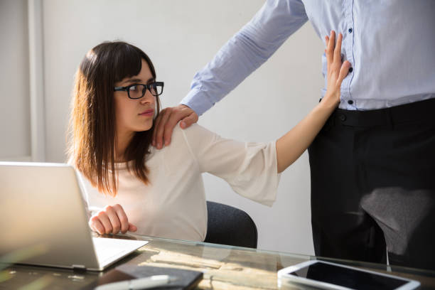 istock Woman Defending Herself From Sexual Harassment By Boss 975124272