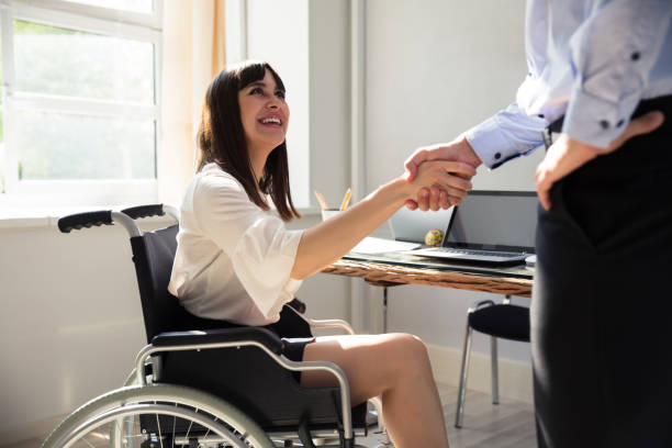 istock Disabled Businesswoman Shaking Hand With Her Partner 975124384