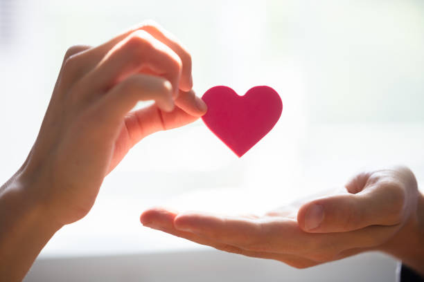 istock Woman Giving Heart On Man's Hand 975126292