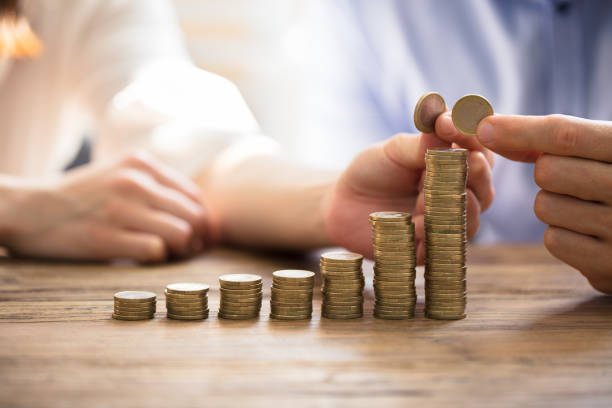 istock Couple Stacking Golden Coins 975126316
