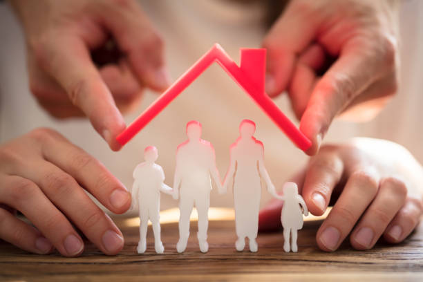 istock Two People Protecting Family Figures 975126326