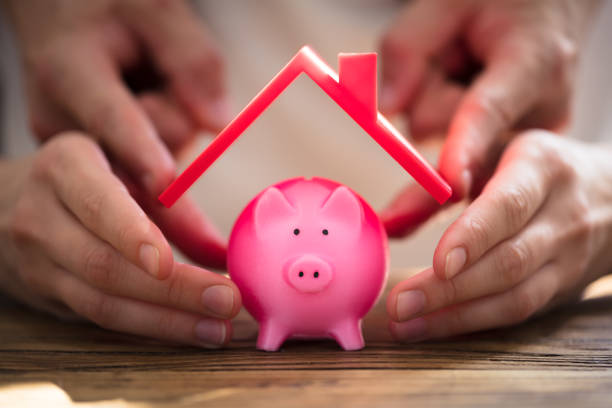 istock Two People Protecting Pink Piggybank 975126360