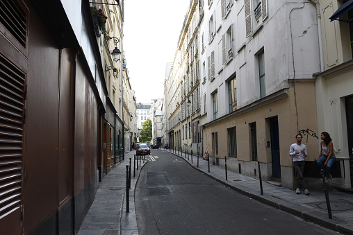 A couple takes on a side street in Paris's Bastille district.