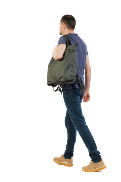 istock back view of walking  man  with green bag. 975152112