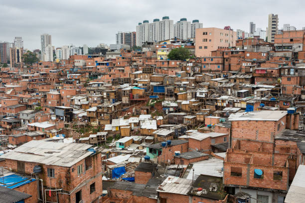 vista del barrio de chabolas "paraisopolis" con altos edificios estándar en el fondo en la ciudad de sao paulo, brasil. - developing countries urban scene outdoors horizontal fotografías e imágenes de stock