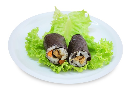Japanese Cuisine, Traditional Vagetarian Japanese Rice Maki Sushi Roll Stuff with Tofu and Carrot Wrapped in Nori Seaweed Served on Green Oak.