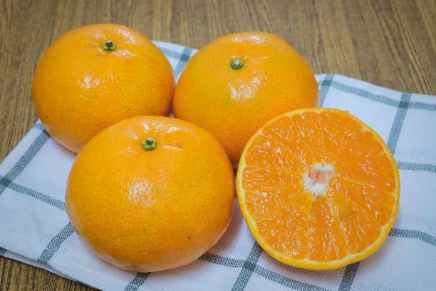 naranjas maduras y dulces en una mesa de madera - zumo 660 fotografías e imágenes de stock