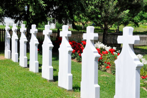 istock Crosses in cemetery. White gravestones going in perspective. 975205498