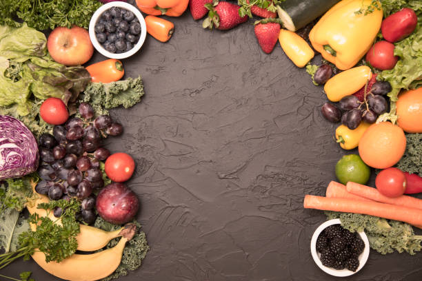 istock Healthy fruits and vegetables on black background 975205690