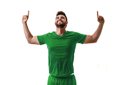 Professional soccer player with green Mexico national team jersey about to score a goal with an expression of challenge and decision on his face on white background.