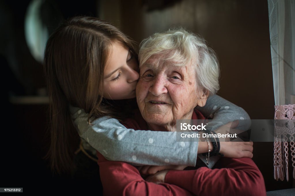 A little girl hugs her grandmother. Grandmother Stock Photo