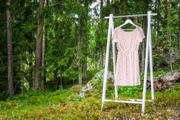 istock Organic clothes on hangers in forest 975214592