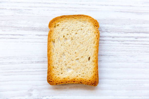 istock Single toast over white wooden background, top view. 975228998