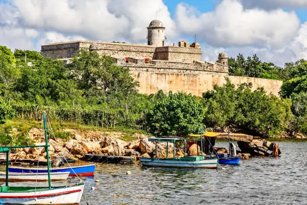 Jagua castle fortified walls with trees and fishing boats in the foreground, Cienfuegos province, Cuba