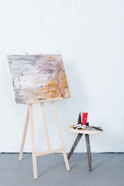 istock painting on easel and paints on stool in creative workshop 975248656