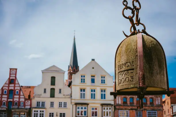 Weight of old Crane hanging in front of facade of historical buildings in Harbor Lueneburg, Lower Saxony,Germany.
