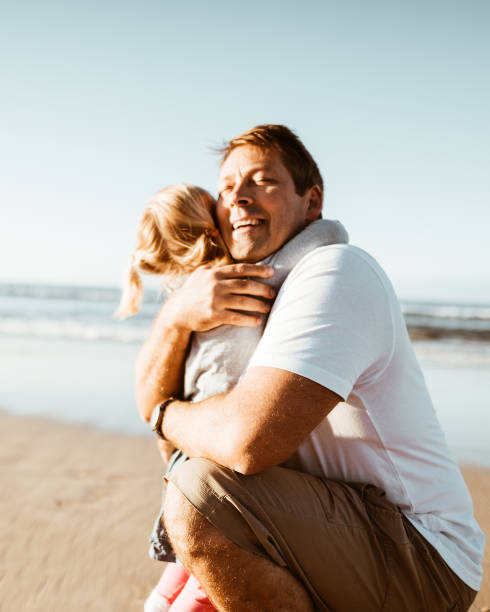 istock little daughter have fun with the dad on the beach 975259270