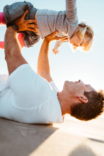 istock little daughter have fun with the dad on the beach 975261754