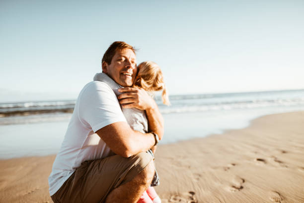 istock little daughter have fun with the dad on the beach 975262090