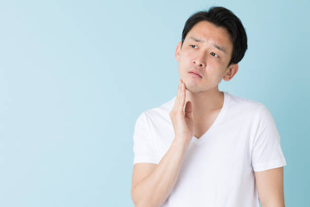 portrait of young asian man isolated on blue background portrait of young asian man isolated on blue background hair stubble stock pictures, royalty-free photos & images