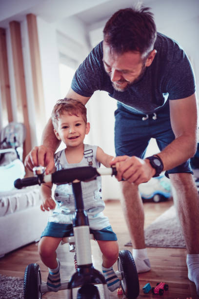 istock Father Teaching His Baby Son How To Ride A Tricycle 975286492