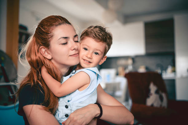 istock Mother Embracing Her Cute Smiling Baby Son 975289698