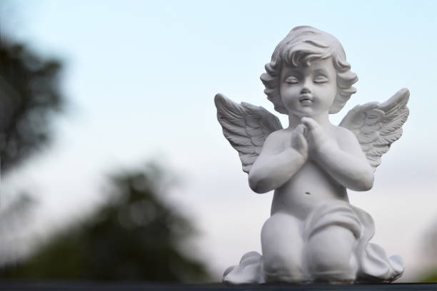 istock Angel guardian kneeling and praying 975290770