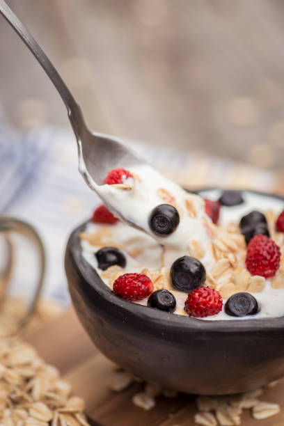 istock Yogurt. Stone bowl with fresh yogurt and berries on rustic table 975307670