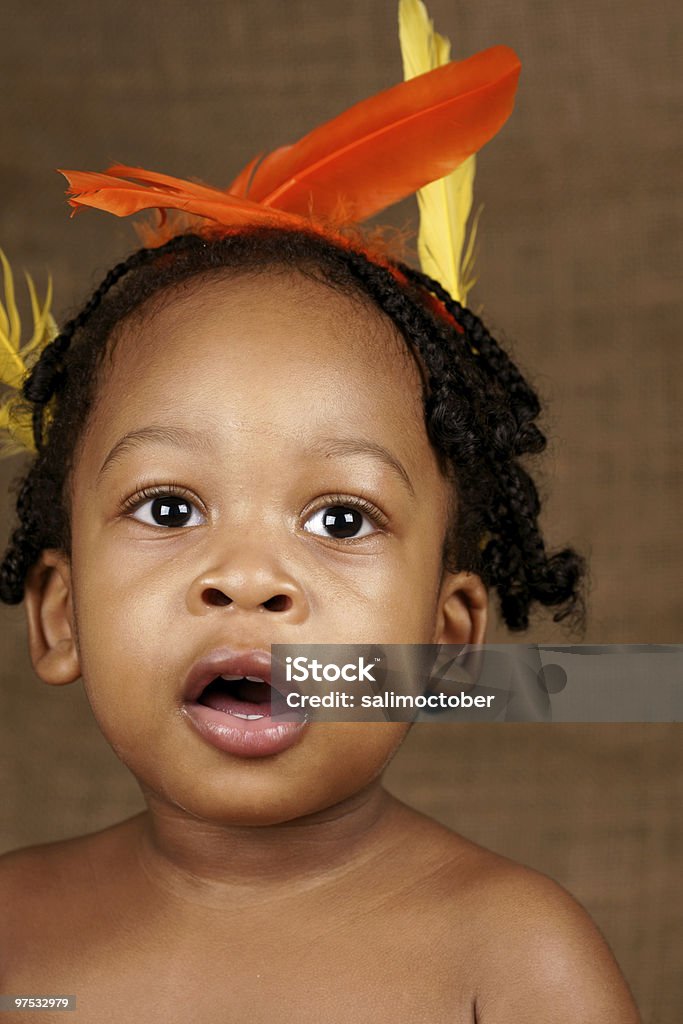 Niño pequeño con feathers en el cabello - Foto de stock de Primer plano libre de derechos