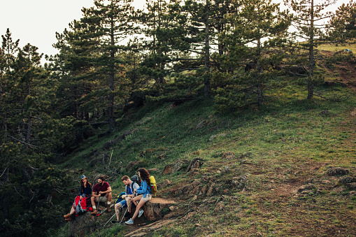 Shot of a group of friends taking a break while trekking in the mountains