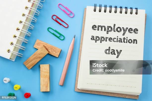 Text Employee Appreciation Day On White Paper Book And Office Supplies On Blue Desk Business Concept Stock Photo - Download Image Now