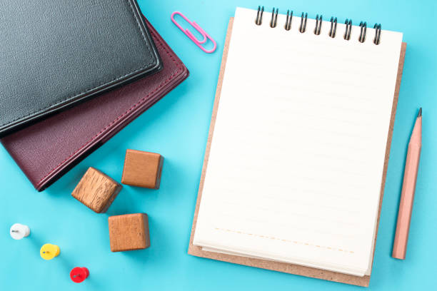 istock blank white paper with pencil on blue table. copy space, top view 975398100