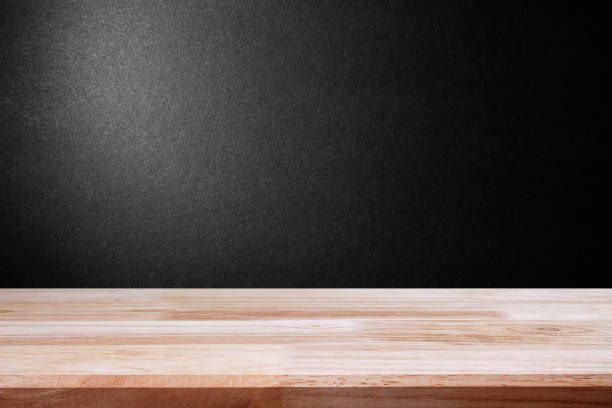 istock empty wooden on black backdrop with spotlight. Wood table top. can used for display or montage your products 975462386