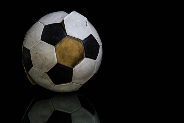 istock Isolated Old Soccer ball on Black 975466196