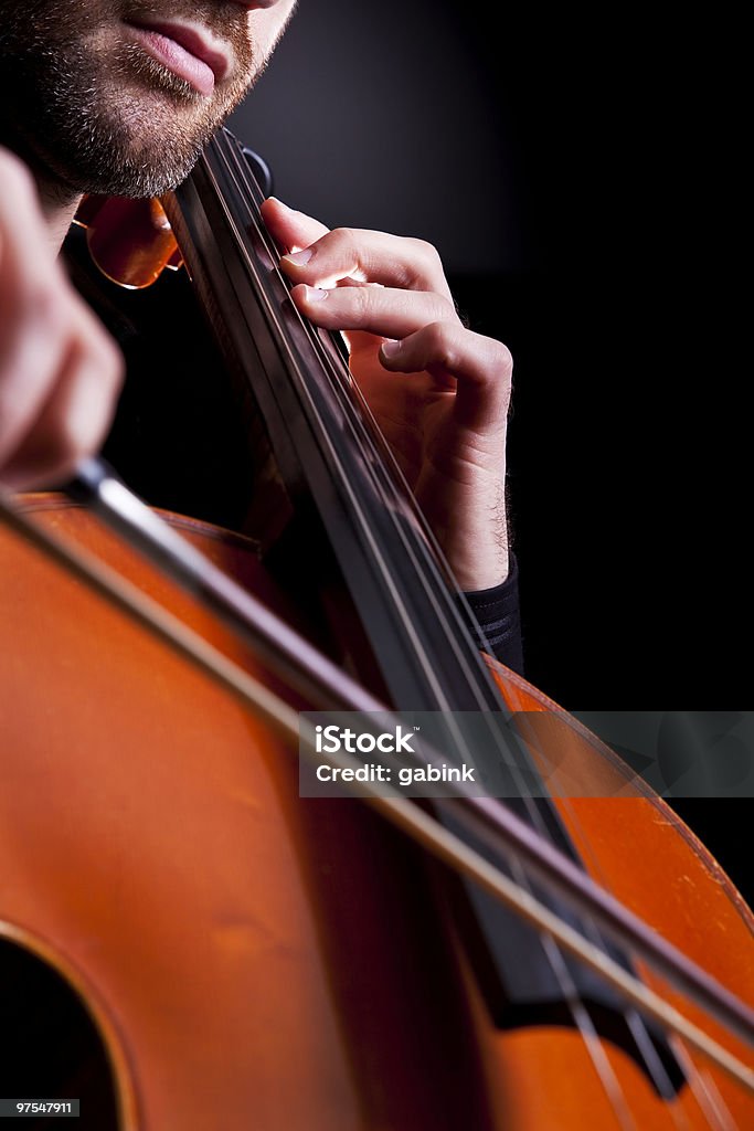 Cellist playing in studio Cellist playing in studio, detail on hand. Backgrounds Stock Photo