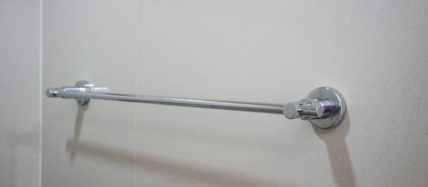 istock Stainless silver towel rail mounted on grey tile wall. Bathroom accessories detail. 975489406