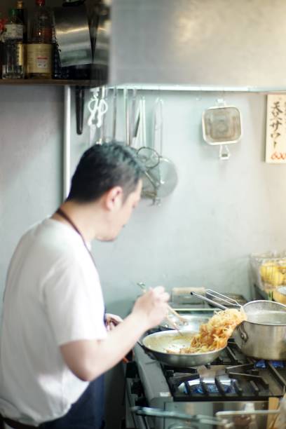 istock Man cooking in a kitchen at Japanese pub 975500450