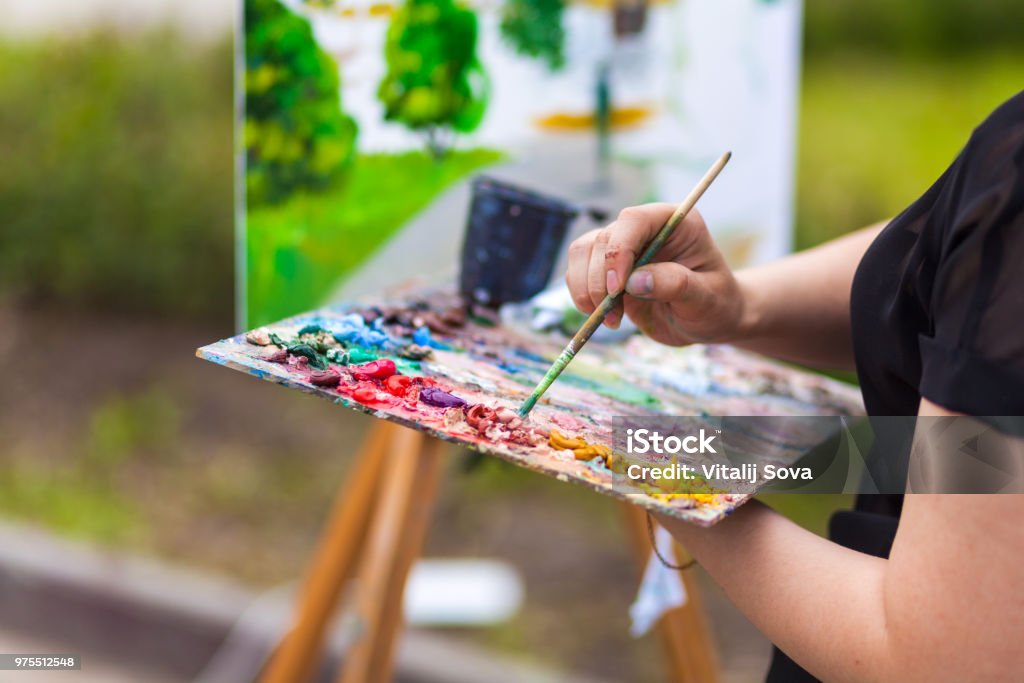 Artist paint summer park A close-up artist paints on a canvas an urban landscape of a summer embankment with atractions of oil paints Painting - Activity Stock Photo