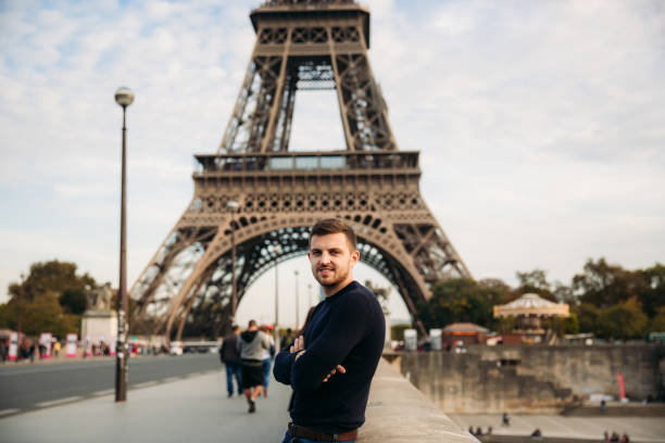 istock Handsome man in dark pullover is standing on the bridge background of the Eiffel Tower 975565510