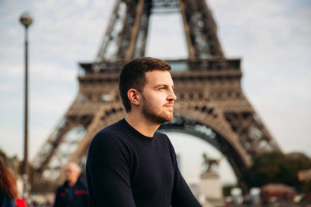 istock Handsome man in dark pullover is standing on the bridge background of the Eiffel Tower 975565524