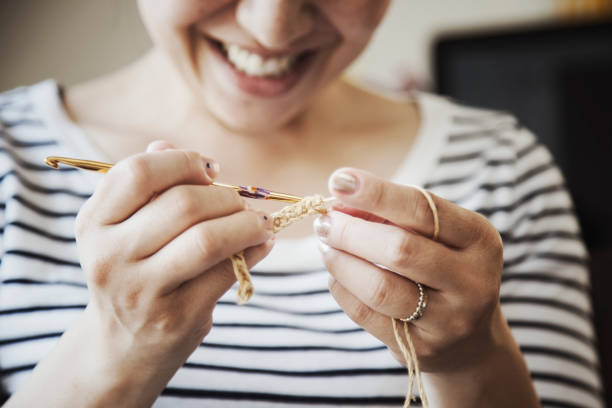 Hands of asian woman sewing at home.