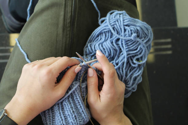 istock Knitting. Female hands with knitting needles. Top view. Close-up. 975580768