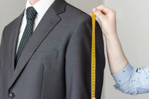 istock The tailor takes measurements from the suit, white background, isolated 975580810