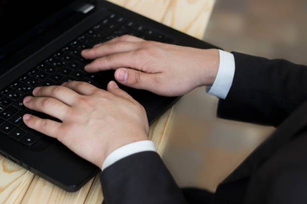istock A man in a business suit is typing on a laptop. 975580818